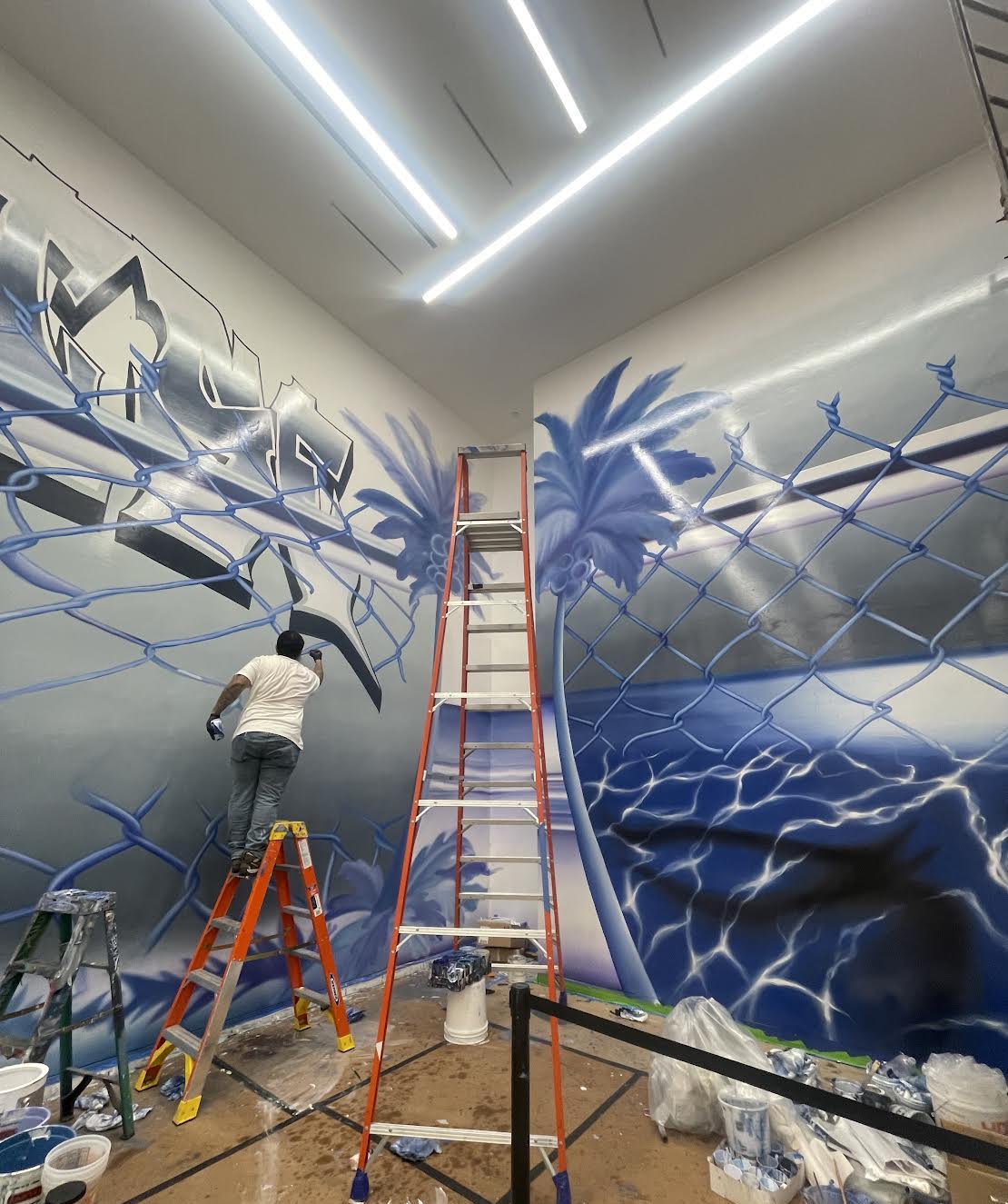 Abstract ocean-inspired mural in shades of blue painted across curved wall at Hammer Museum LA