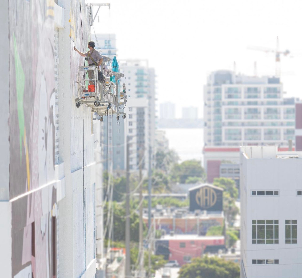 Closeup of a Hoist Media muralist painting a New Balance campaign mural on in Miami